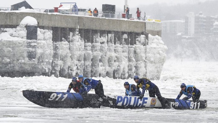 Some of the 50 teams take the start of the Quebec Winter Carnival ice canoe race across the St. Lawrence River, Sunday, Feb. 5, 2023, in Quebec City. (Jacques Boissinot/The Canadian Press via AP)