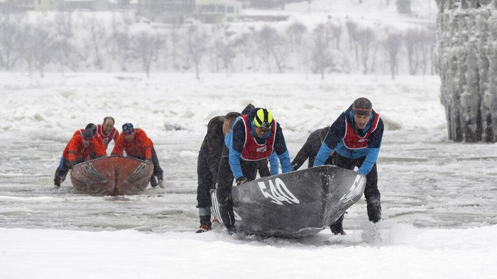 Some of the 50 teams take the start of the Quebec Winter Carnival ice canoe race across the St. Lawrence River, Sunday, Feb. 5, 2023, in Quebec City. (Jacques Boissinot/The Canadian Press via AP)