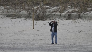Warga setempat mengamati proses pencarian dengan bantuan teropong. Foto: Getty Images