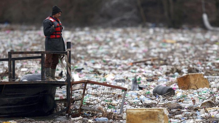 Penampakan Sampah yang Memenuhi Sungai Lim di Serbia Utility company workers push the waste to the shore of Lim river near Priboj, Serbia, Monday, Jan. 30, 2023. Plastic bottles, wooden planks, rusty barrels and other garbage dumped in poorly regulated riverside landfills or directly into the rivers accumulated during high water season, behind a trash barrier in the Lim river in southwestern Serbia. (AP Photo/Armin Durgut)