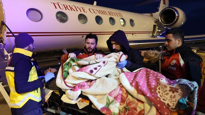 Pesawat Presiden Turki Bantu Evakuasi Korban Gempa ADIYAMAN, TURKYIE - FEBRUARY 07: People injured in the earthquake in Adiyaman put on Turkish Presidency planes by the medical teams to be taken to Ankara in Adiyaman, Turkiye on February 07, 2023. The planes carry food, medical equipment, generators, clothes as well as emergency personnel to the disaster area. Early Monday morning, a strong 7.7 earthquake, centered in the Pazarcik district, jolted Kahramanmaras and strongly shook several provinces, including Gaziantep, Sanliurfa, Diyarbakir, Adana, Adiyaman, Malatya, Osmaniye, Hatay, and Kilis. Later, at 13.24 p.m. (1024GMT), a 7.6 magnitude quake centered in Kahramanmaras' Elbistan district struck the region. Turkiye declared 7 days of national mourning after deadly earthquakes in southern provinces. (Photo by Halil Sagirkaya/Anadolu Agency via Getty Images)