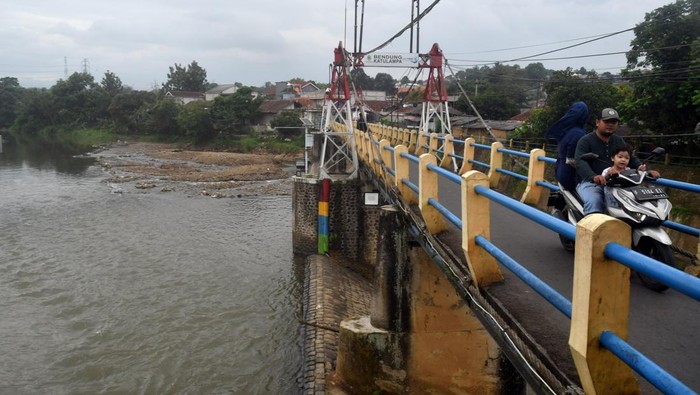 Potret Debit Air di Bendung Katulampa yang Menyusut Pengendara motor melintas di jembatan Bendung Katulampa, Kota Bogor, Jawa Barat, Rabu (8/2/2023). Debit air Sungai Ciliwung di Bendung Katulampa mengalami penyusutan dengan Tinggi Muka Air (TMA) hanya nol centimeter akibat kawasan hulu atau Puncak, Kabupaten Bogor tidak mengalami hujan deras sejak sepekan ini. ANTARA FOTO/Arif Firmansyah/rwa.