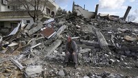 Seorang warga menangis sambil memandangi rumah-rumah yang rata dengan tanah akibat gempa M 7,8 di Osmaniye, Turki. AP Photo/Khalil Hamra.