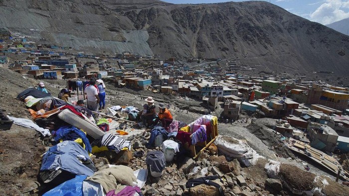 Rumah-rumah di Peru Hancur Tertimbun Longsor, 15 Orang Tewas Residents walk on a street covered with debris caused by a landslide, in Camana, Peru, Tuesday, Feb. 7, 2023. Authorities in Peru say landslides triggered by steady rains swept mud, water and rocks into several villages in the country's southern region. (AP Photo/Jose Sotomayor)