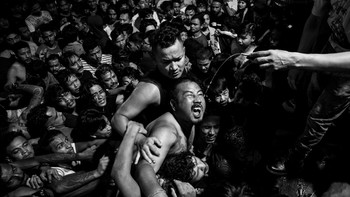 Karya Rabik Upadhayay dari Nepal. Para pemuda berdesak-desakan untuk minum alkohol sebagai bagian dari praktik budaya selama Festival Indra Jatra di Kathmandu, Nepal. Selama perayaan selama seminggu, sebuah patung Swet Bhairab (tidak terlihat dalam gambar ini) diresmikan dan alkohol disajikan melalui pipa kuningan yang keluar dari mulut sang idola. Ini adalah pengalaman yang gila, bahkan untuk penonton, dengan banyak peserta yang cedera setiap tahun. Foto: The World Photography Organisation