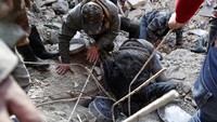 Tim SAR harus kerja keras untuk mencari korban di reruntuhan bangunan di Aleppo, Suriah. Bahkan mereka harus mengintip melalui celah sempit reruntuhan bangunan. AP Photo/Omar Sanadiki.