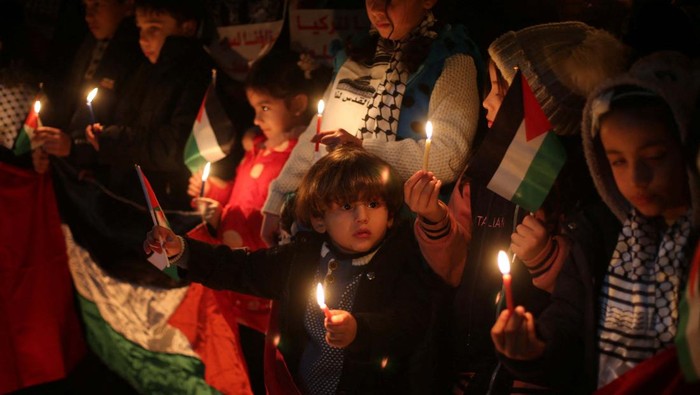 Palestinian children light candles to express solidarity with the victims of an earthquake in Turkey and Syria, in Khan Younis in southern Gaza Strip February 7, 2023. REUTERS/Ibraheem Abu Mustafa