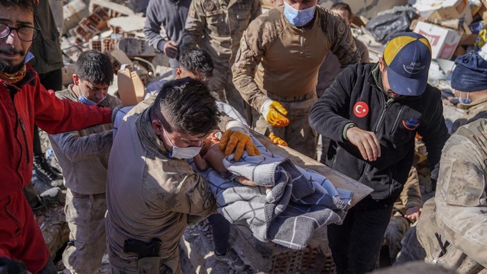 HATAY, ANTAKYA, TURKEY - 2023/02/08: Soldiers carry a 20-day-old baby who was rescued 59 hours after the earthquake to an ambulance. After the baby, who was stuck in the wreckage with his mother, was rescued, he was transported to the ambulance by the soldiers and treated. The baby was reported to be in good health. Rescue efforts continue for his mother. Turkey experienced the biggest earthquake of this century in the border region with Syria. The earthquake was measured at 7.7 magnitude. Many buildings in the area were destroyed. Search and rescue works are on-going. (Photo by Ibrahim Oner/SOPA Images/LightRocket via Getty Images)