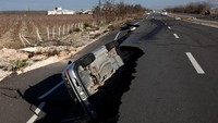 Sebuah mobil terbalik, terlihat terjebak di salah satu celah.  