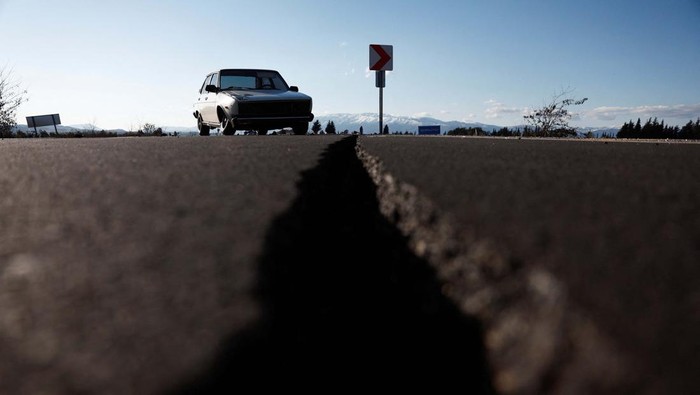 Jalan Pecah Akibat Gempa di Demirkopru Turki, Mobil-mobil Terperosok A car is pictured on an earthquake damaged D420 road in Demirkopru, Turkey, February 8, 2023. REUTERS/Benoit Tessier