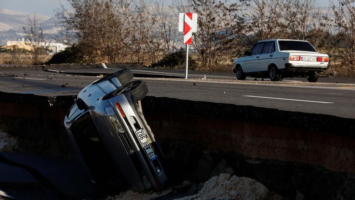 Jalan Pecah Akibat Gempa di Demirkopru Turki, Mobil-mobil Terperosok A car is pictured on an earthquake damaged D420 road in Demirkopru, Turkey, February 8, 2023. REUTERS/Benoit Tessier
