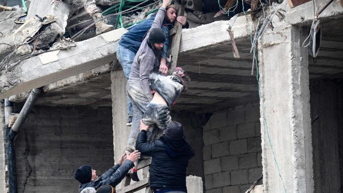 HATAY, TURKIYE - FEBRUARY 06: A child is being rescued under rubble after 7.7 magnitude earthquake hits Turkiyeâs southern provinces, in Iskenderun district of Hatay, Turkiye on February 06, 2023. Disaster and Emergency Management Authority (AFAD) of Turkiye said the 7.7 magnitude quake struck at 4.17 a.m. (0117GMT) and was centered in the Pazarcik district in Turkiyeâs southern province of Kahramanmaras. Gaziantep, Sanliurfa, Diyarbakir, Adana, Adiyaman, Malatya, Osmaniye, Hatay, and Kilis provinces are heavily affected by the quake. (Photo by Sezgin Pancar/Anadolu Agency via Getty Images)