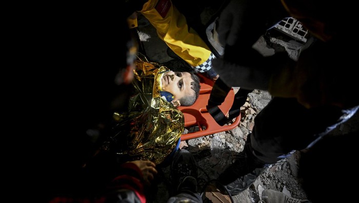 HATAY, TURKIYE - FEBRUARY 06: A child is being rescued under rubble after 7.7 magnitude earthquake hits Turkiyeâs southern provinces, in Iskenderun district of Hatay, Turkiye on February 06, 2023. Disaster and Emergency Management Authority (AFAD) of Turkiye said the 7.7 magnitude quake struck at 4.17 a.m. (0117GMT) and was centered in the Pazarcik district in Turkiyeâs southern province of Kahramanmaras. Gaziantep, Sanliurfa, Diyarbakir, Adana, Adiyaman, Malatya, Osmaniye, Hatay, and Kilis provinces are heavily affected by the quake. (Photo by Sezgin Pancar/Anadolu Agency via Getty Images)