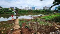 Warga memanfaatkan perahu eretan untuk menyeberangi Sungai Banjir Kanal Barat, Jakarta Barat, Kamis (9/2/2023).