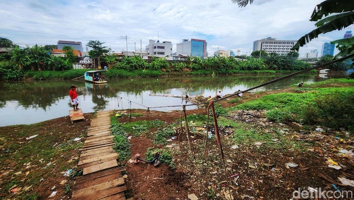 Masih Ada! Perahu Eretan di Pusat Jakarta Warga memanfaatkan perahu eretan yang melintas di Sungai Banjir Kanal Barat, Jakarta Barat, Kamis (9/2/2023). Perahu eretan ini menghubungkan Kota Bambu Utara, Jakbar dengan kawasan Cideng, Jakarta Pusat. Sekali tempuh, pengguna membayar Rp 2.000. Perahu eretan memangkas jarak jika harus melewati jembatan besi yang jumlahnya tak banyak.
