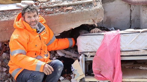 Mesut Hancer memegang tangan putrinya yang berusia 15 tahun (Irmak) yang meninggal dalam gempa bumi di Kahramanmaras, setelah gempa berkekuatan 7,8 melanda tenggara negara itu, pada (7/2/2023). (AFP/ADEM ALTAN)