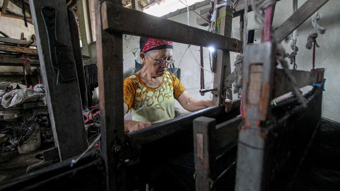 Perajin membuat sarung tenun dengan alat tenun bukan mesin (ATBM) di Turirejo, Lawang, Malang, Jawa Timur, Kamis (9/2/2023). Industri sarung tenun rumahan yang berkembang sejak tahun 1950-an di kawasan itu kini kekurangan tenaga terampil dari yang semula berjumlah 40-50 perajin sekarang tersisa enam perajin karena minimnya regenerasi. ANTARA FOTO/Muhammad Mada/foc.
