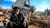 Seorang pria duduk meratapi wilayah tempat tinggalnya yang hancur akibat gempa di Maras, Turki, Rabu (8/2/2023). (Yavuz Ozden/Getty Images)  