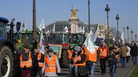 Para petani membawa bendera serikat pekerja di depan museum Grand Palais di Esplanade des Invalides. Mereka menuntut pemerintah atas pembatasan pestisida yang dinilai akan mengancam produksi pertanian.  