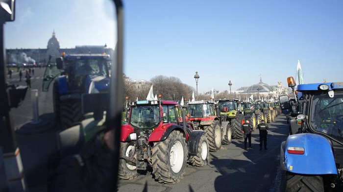 Ratusan Petani Bawa Traktor ke Paris, Protes Larangan Pestisida Tractors drive past the Invalides monument in Paris, Wednesday, Feb. 8, 2023. French sugarbeet and other farmers disrupt Paris traffic with hundreds of tractors to protest an EU pesticide ban they say will devastate their livelihoods and industry. (AP Photo/Christophe Ena)