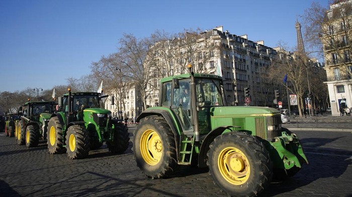 Tractors drive past the Invalides monument in Paris, Wednesday, Feb. 8, 2023. French sugarbeet and other farmers disrupt Paris traffic with hundreds of tractors to protest an EU pesticide ban they say will devastate their livelihoods and industry. (AP Photo/Christophe Ena)