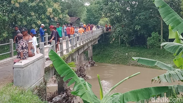 Warga dan relawan berada di jembatan Desa Karangjoho, Kecamatan Karangdowo, Klaten, mencari keberadaan korban, Kamis (9/2/2023).