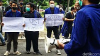 Mereka membawa atribut aksi seperti poster.