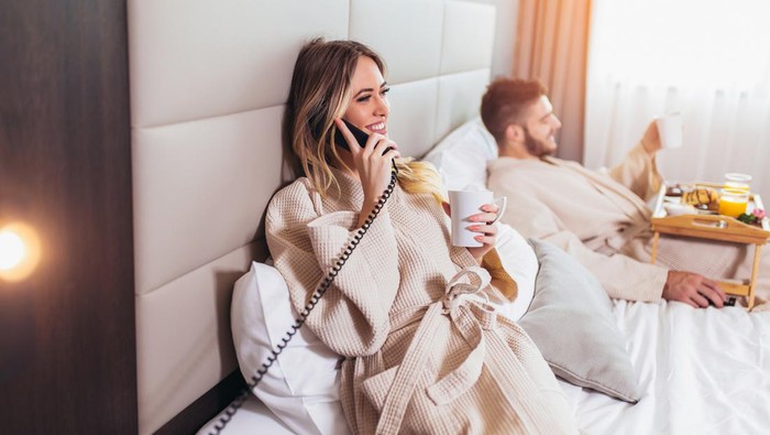 Woman calling room service for food from hotel room