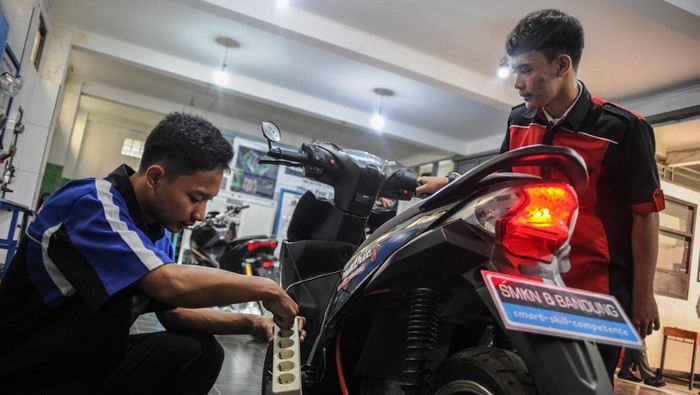 Keren, Siswa SMKN di Bandung Konversikan Motor BBM Jadi Motor Listrik Siswa SMK memeriksa komponen sepeda motor berbahan bakar minyak yang telah dikonversikan ke listrik di SMKN 8 Bandung, Jawa Barat, Jumat (10/2/2023). Siswa kelas XI SMKN 8 mengkonversikan motor bahan bakar minyak ke tenaga listrik yang diberi nama Matric 8 dengan daya 3.000 watt serta mampu menempuh jarak 50 kilometer.