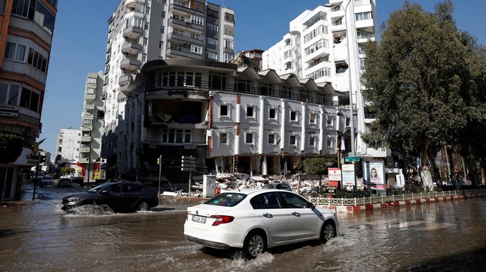 A truck drives on a street flooded by sea water, on a coastal road, following a deadly earthquake in Iskenderun, Turkey, February 9, 2023. REUTERS/Benoit Tessier