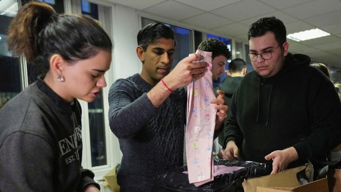 Britain's Prime Minister Rishi Sunak helps to pack the supplies at a donation centre that is supporting the Turkey earthquake appeal, in London, Thursday, Feb. 9, 2023. Kin Cheung/Pool via REUTERS