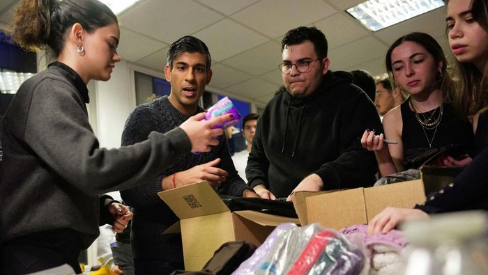 Britain's Prime Minister Rishi Sunak helps to pack the supplies at a donation centre that is supporting the Turkey earthquake appeal, in London, Thursday, Feb. 9, 2023. Kin Cheung/Pool via REUTERS