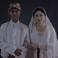 Kisah pengantin beda warna kulit ini viral usai Arum Puspitasari sang pengantin wanita membagikan momen pernikahannya lewat akun TikTok @arumpps. Dalam video terlihat Arum dan suaminya sedang berada di pelaminan. Arum juga memperlihatkan foto saat memakai kebaya putih adat Jawa. Sedangkan suaminya yang asal Jawa dengan akun @jitengwongjowo, mengenakan blankon dan beskap putih. Foto: Dok. TikTok @arumpps.