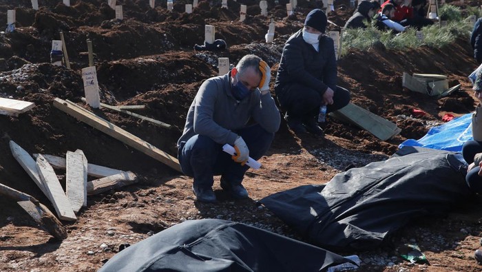 A man reacts next to the graves of victims of the deadly earthquake, in a cemetery in Kahramanmaras, Turkey, February 9, 2023. REUTERS/Dilara Senkaya