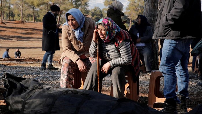 Turki Mulai Pemakaman Massal Korban Gempa di Kahramanmaras Women mourn for a relative at a cemetery of victims of the deadly earthquake, in Kahramanmaras, Turkey, February 9, 2023. REUTERS/Dilara Senkaya TPX IMAGES OF THE DAY