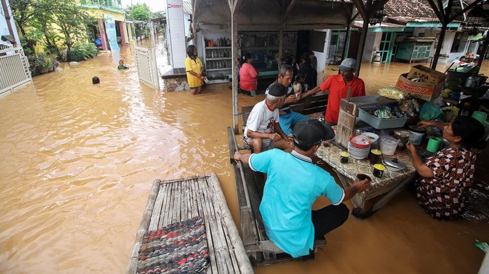 BANJIR DI GRATI PASURUAN Warga melintasi banjir di Desa Kedawung, Grati, Pasuruan, Jawa Timur, Sabtu (11/2/2023). Hujan deras dengan intensitas tinggi tersebut mengakibatkan belasan desa di tiga kecamatan wilayah timur Kabupaten Pasuruan terendam banjir dengan ketinggian hingga satu meter. ANTARA FOTO/Umarul Faruq/rwa.
