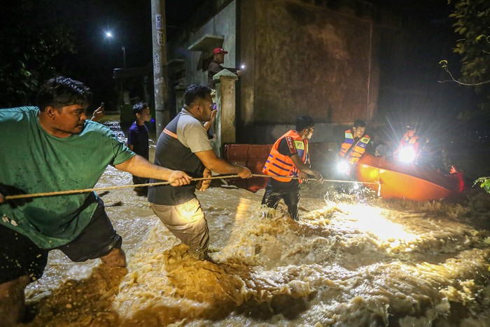 Petugas BPBD Aceh Besar mengevakuasi warga yang terjebak banjir menggunakan perahu di Gampong Teupin Batee, Kecamatan Blang Bintang, Aceh Besar, Aceh, Sabtu (11/2/2023). Banjir yang disebabkan tingginya intensitas hujan tersebut mengakibatkan air Sungai Lingkar meluap sehingga merendam puluhan rumah penduduk dengan ketinggian air antara 30 centimeter hingga 1,5 meter. ANTARA FOTO/Khalis Surry/rwa.