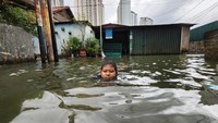 Anak-anak asyik bermain air bak di kolam renang.