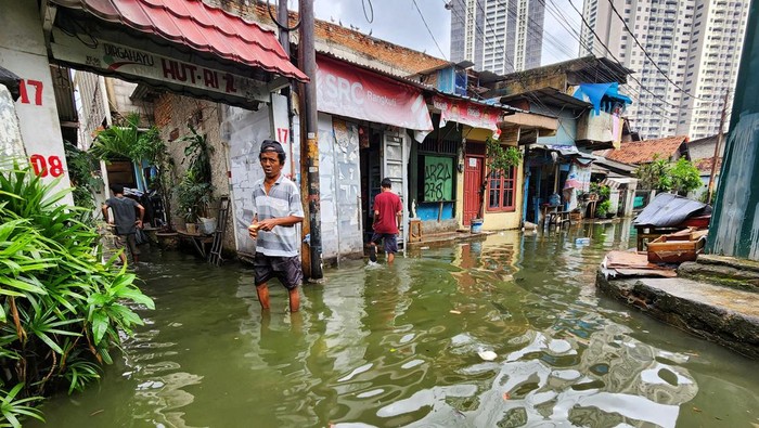 Warga dan anak-anak beraktivitas di tengah genangan di Jl Ophir Dalam, RT 007/001, Kelurahan Gunung, Kebayoran Baru, Jakarta Selatan, Sabtu (11/2/2023). Genangan terpantau sekitar 40 cm pada pukul 11.15 WIB. Air naik sejak pagi saat curah hujan tinggi sekitar pukul 06.30 WIB. Genangan ini merupakan limpahan air dari anak kali yang melintasi kawasan tersebut.