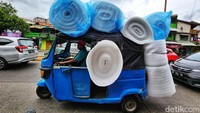 Bajaj itu membawa banyak barang hingga melebihi muatan.