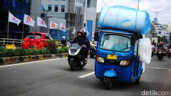 Potret Bajaj Kelebihan Muatan di Slipi Sebuah kendaraan roda tiga Bajaj terlihat membawa muatan berlebih saat melintas di Jl KS Tubun, Jakarta Pusat, Sabtu (11/2/2023). Saat menanjak di flyover Slipi, salah satu muatannya terjatuh ke aspal.