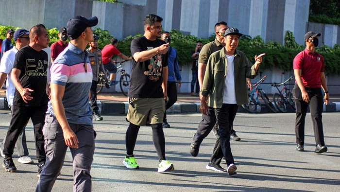 Presiden Joko Widodo (kedua kanan) didampingi Gubernur Sumatera Utara Edy Rahmayadi (kiri) dan Walikota Medan (ketiga kiri) menyapa warga  saat Car Free Day (CFD)  di Kota Medan, Suamtera Utara, Minggu (12/2/2023). Selain menyapa warga yang berolahraga di CFD, Presiden juga meninjau pembangunan sejumlah fasilitas yang ada di Kota Medan. ANTARA FOTO/Yudi/Lmo/YU