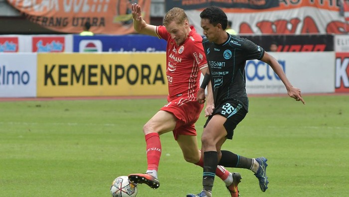 Pesepak Bola Persija Jakarta Aji Kusuma (kanan) dijaga ketat pesepak bola Arema Fc Sergio Domingos (kiri) saat mengoper bola pada lanjutan Liga 1 di Stadion Patriot Chandrabhaga, di Bekasi, Jawa Barat, Minggu (12/2/2023). Persija Jakarta menang dengan skor 2-0.