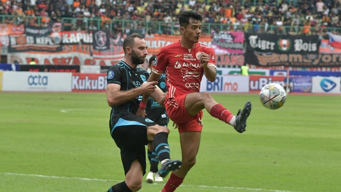 Pesepak Bola Persija Jakarta Aji Kusuma (kanan) dijaga ketat pesepak bola Arema Fc Sergio Domingos (kiri) saat mengoper bola pada lanjutan Liga 1 di Stadion Patriot Chandrabhaga, di Bekasi, Jawa Barat, Minggu (12/2/2023). Persija Jakarta menang dengan skor 2-0.