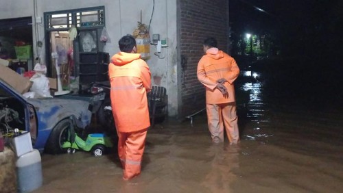 Petugas BPBD Jembrana saat melakukan penyedotan air yang menggenang di rumah warga di Jalan Udayana, Gang Kuburan Cina, Kelurahan Baler Bale Agung, Kecamatan Negara, Jembrana, Bali, Minggu (12/2/2023). (Foto: Istimewa)