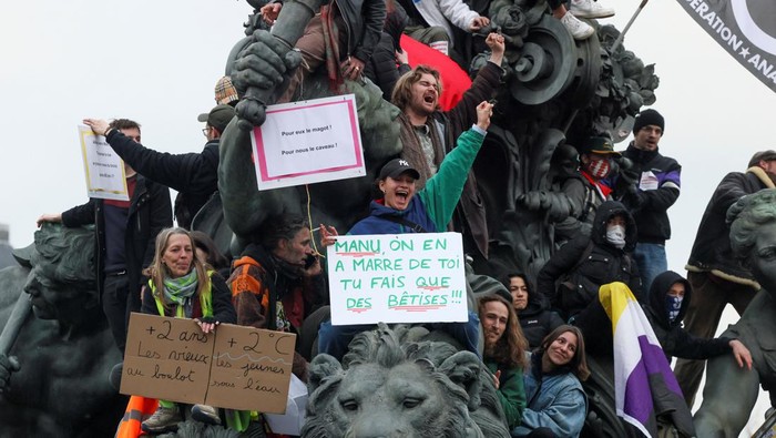 Protes Reformasi Pensiun, Warga Prancis Turun ke Jalan Protesters are on top of a sculpture as they attend a demonstration against the French government's pension reform plan as part of the fourth day of national protests, in Paris, France, February 11, 2023. REUTERS/Yves Herman