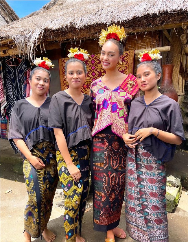 Foto bersama masyarakat lokal, wanita 28 tahun ini mengenakan busana dari kain tenun Nusa Tenggara Barat. Ia memadukan blouse warna cerah dengan kain. Tak lupa aksesori kepala khas Lombok. Foto: Instagram/@rbonneynola