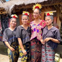 Foto bersama masyarakat lokal, wanita 28 tahun ini mengenakan busana dari kain tenun Nusa Tenggara Barat. Ia memadukan blouse warna cerah dengan kain. Tak lupa aksesori kepala khas Lombok. Foto: Instagram/@rbonneynola