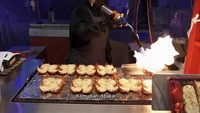 Jajanan lain yang dicoba oleh Ria SW adalah lobster. Ia menikmati lobster panggang yang diberikan bumbu gurih dan keju mozzarella super mulur. Foto: YouTube Ria SW