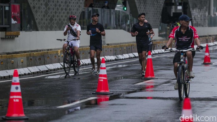 Salut! Warga Berolahrga saat Rintik Hujan Mengguyur Jakarta Hujan mengguyur Jakarta sejak malam hari hingga pagi ini. Meski demikian warga tetap berolahraga di area car free day (CFD) Bundaran HI Jakarta, Minggu (12/2/2023).
